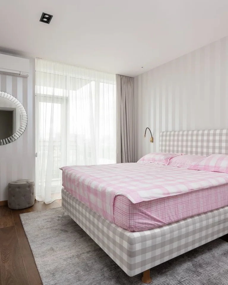 A floating wall shelf styled above a bed with small decor pieces