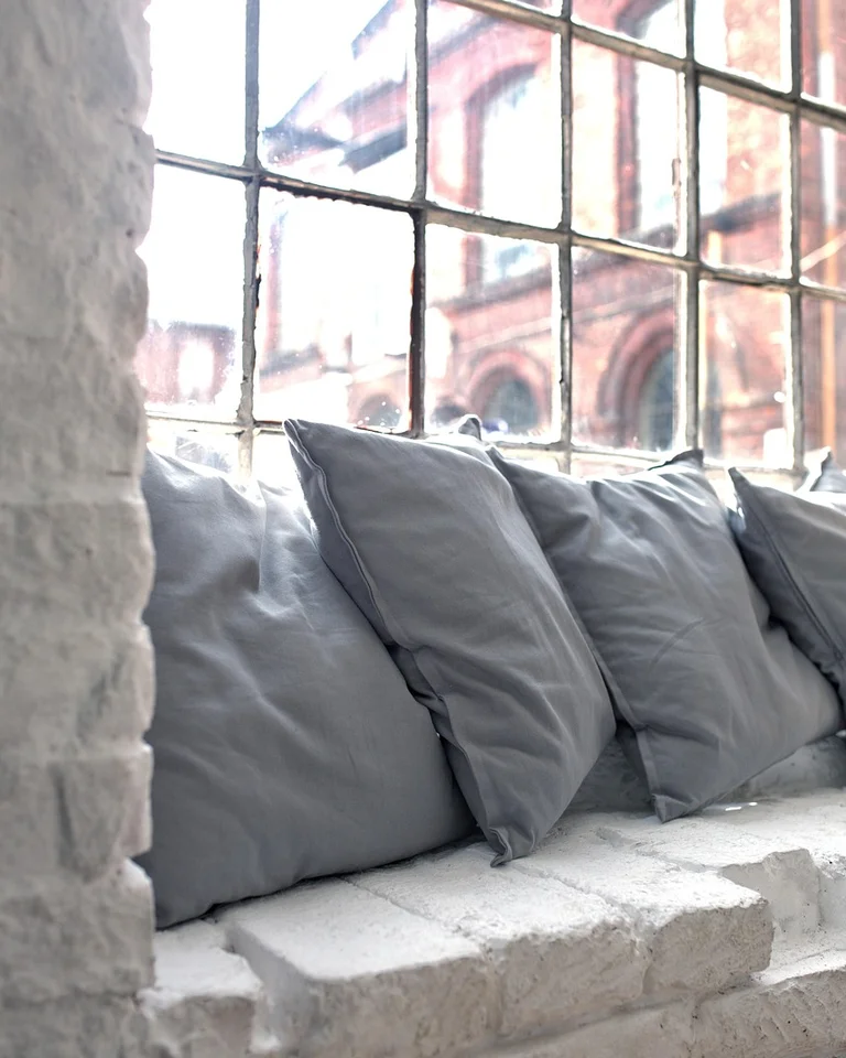 A window seat with cushions and storage drawers beneath in a cozy apartment
