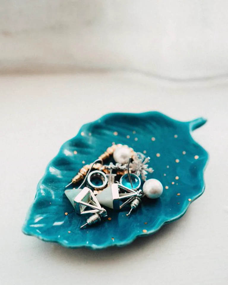 Jewelry dish and everyday essentials arranged neatly on a dresser