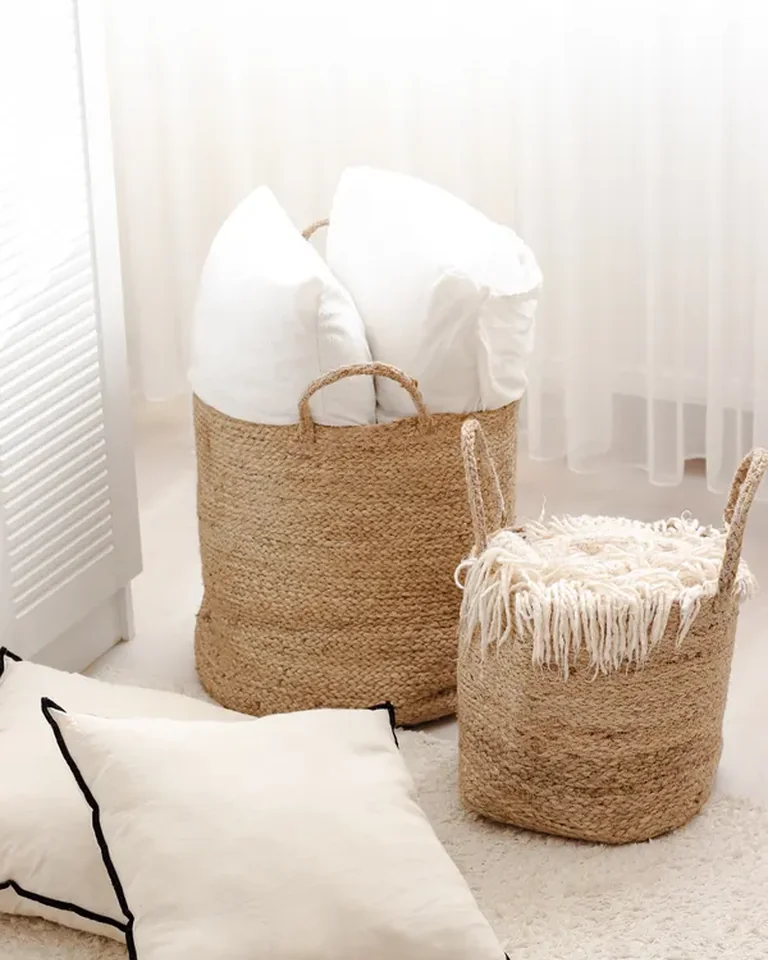 Jute storage baskets holding pillows in a bright bedroom