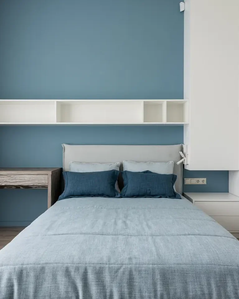 Neat bedroom with a made bed and built-in wall shelves