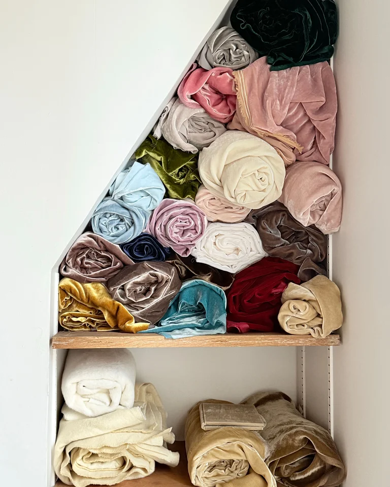 Rolled velvet fabrics neatly stored on shelves