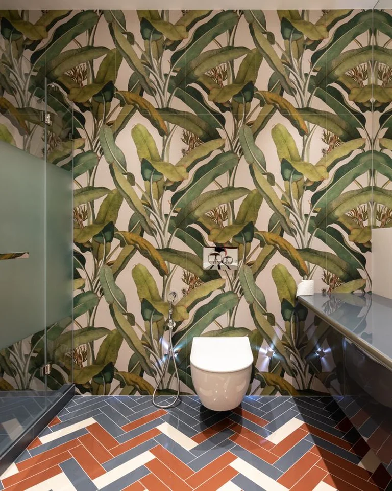 Small bathroom with green botanical wallpaper on one wall behind the toilet