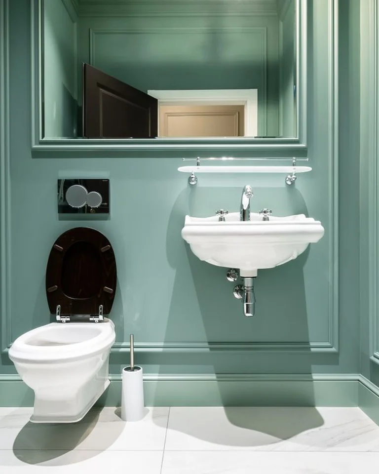 Small bathroom with one deep emerald green accent wall behind a white vanity