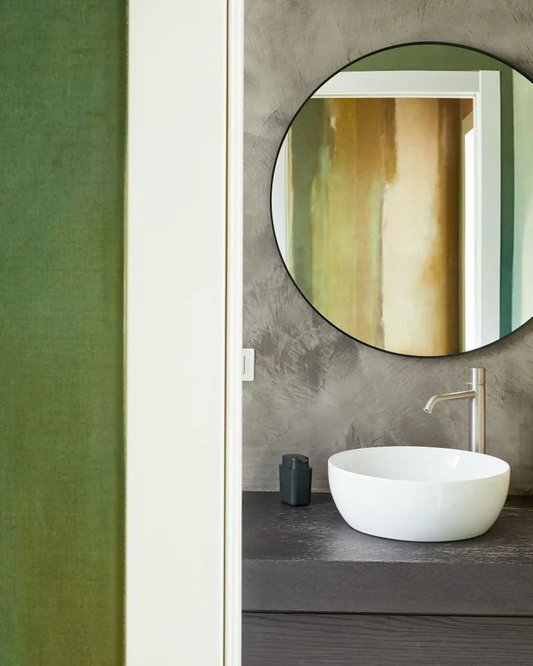 Bathroom layering deep emerald vanity, sage walls, and mint accessories