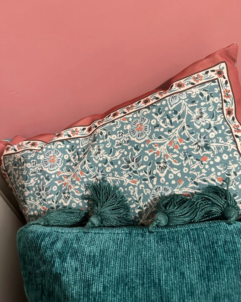 Decorative pillows in blush pink and teal with a floral pattern