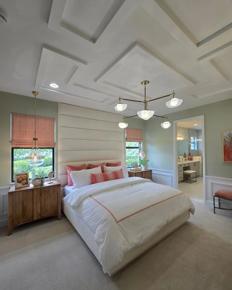 Bedroom with sage green walls, white panel molding, and a coffered ceiling