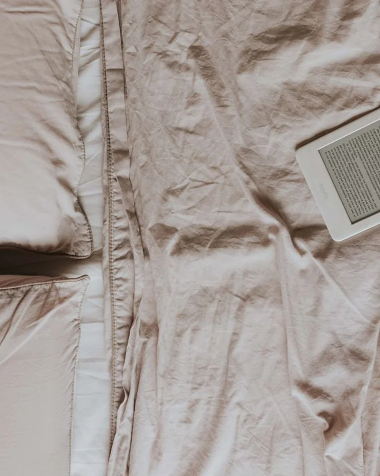 Sage bedroom with cream linen duvet and rumpled natural bedding