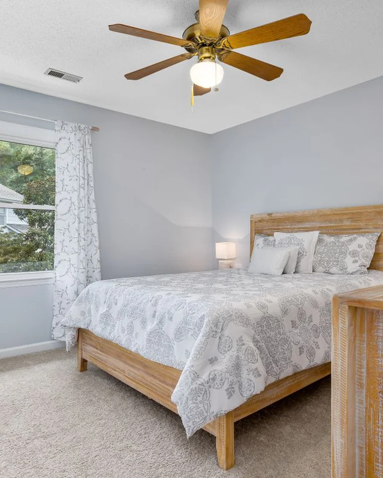 Bedroom with a light wood bed frame and dresser showing how wood warms a muted palette
