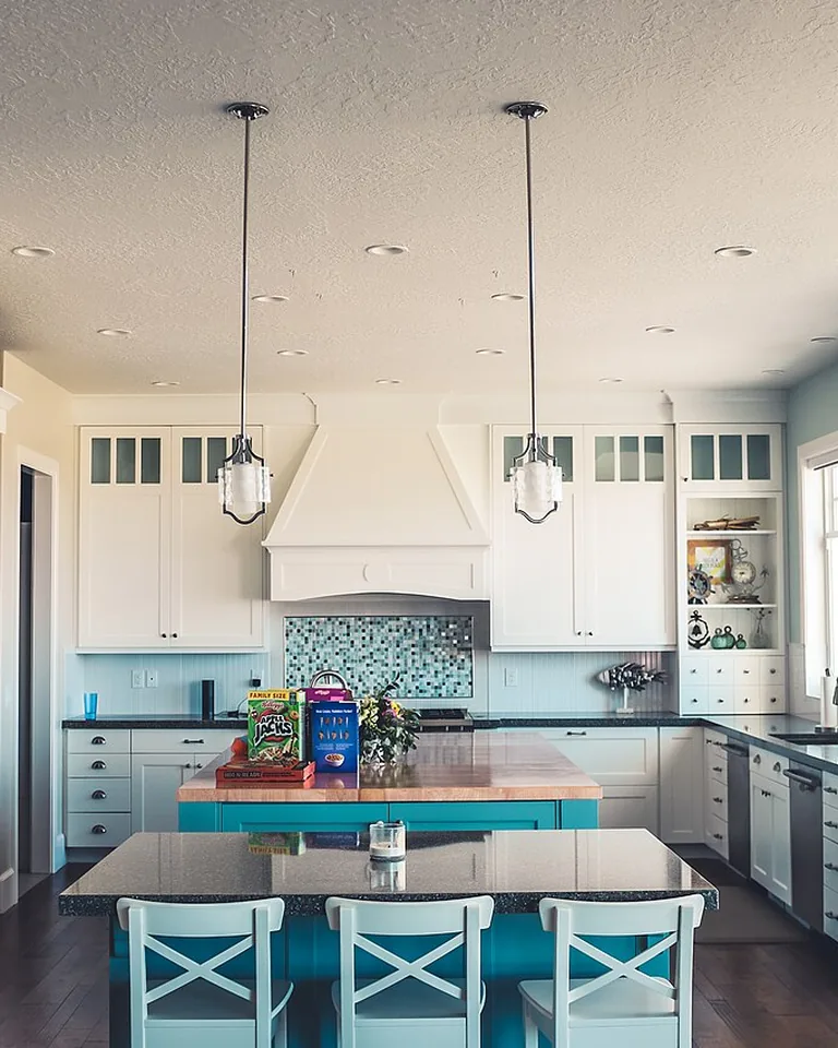 White kitchen with soft blue accents and layered white tones
