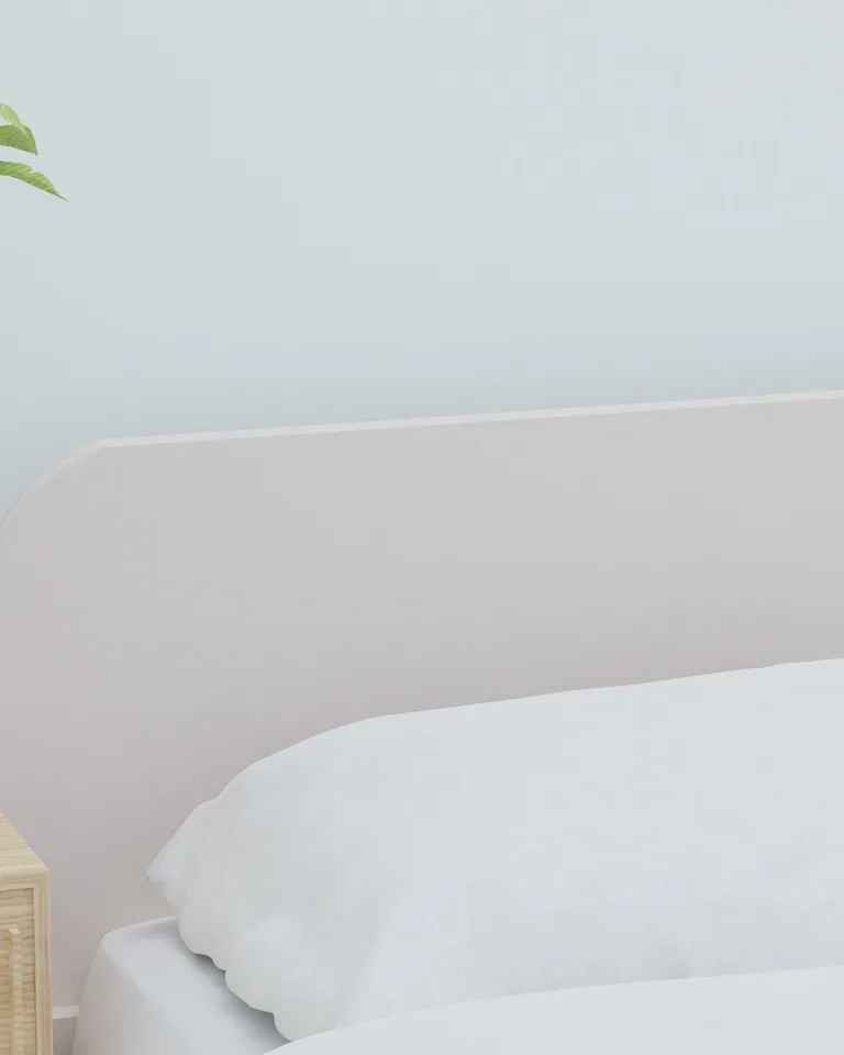 White bedding with a vase of greenery on a wooden nightstand