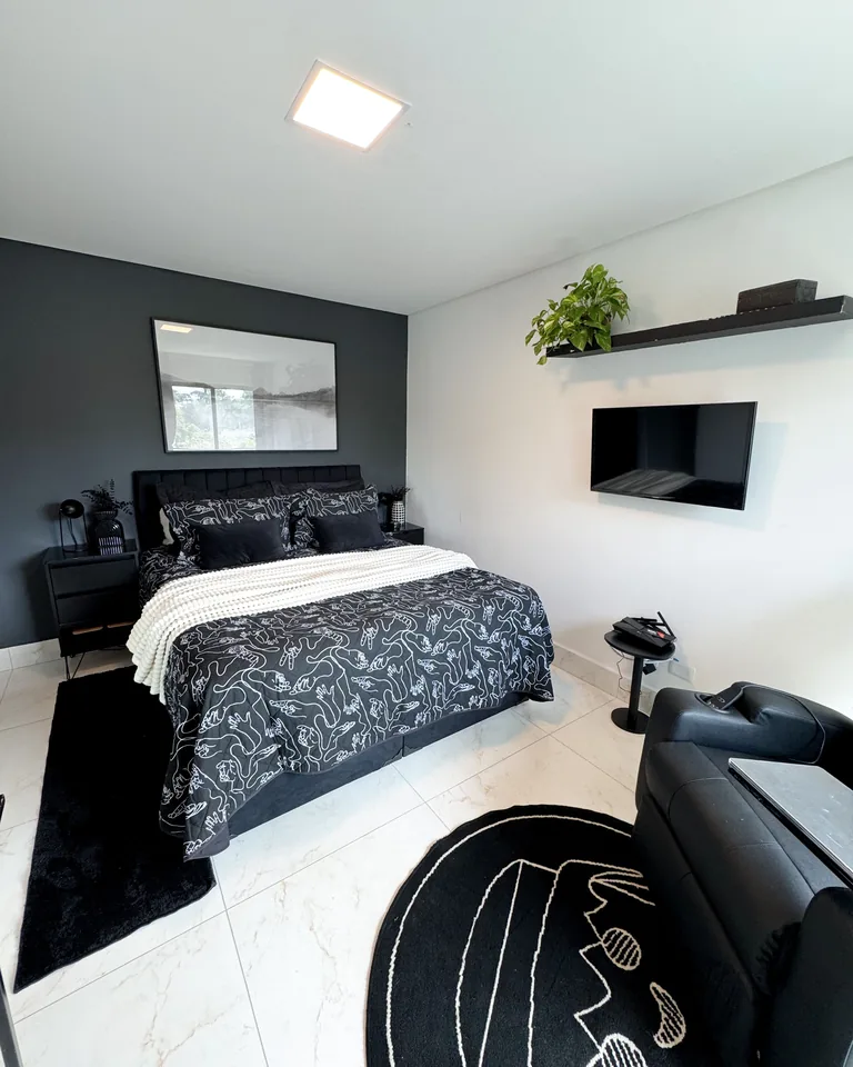 Modern minimalist black and white bedroom with plants and cozy decor