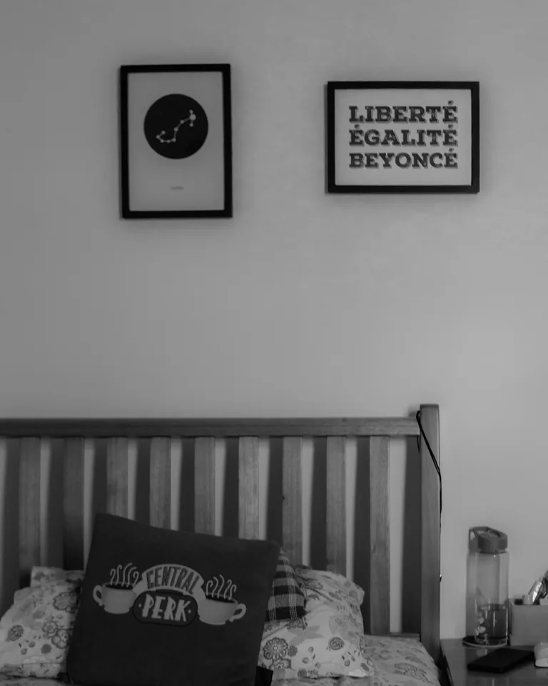 Bedroom with decorative wall art and cushions above the bed