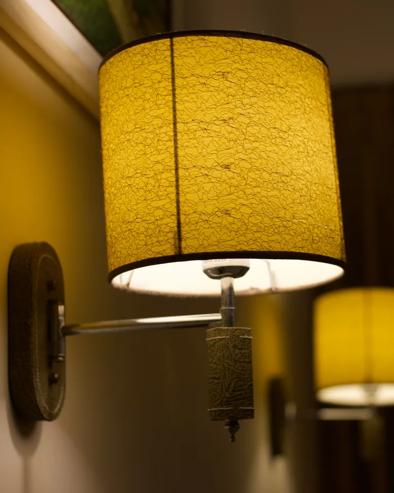 Wall-mounted lamp casting warm light in a bedroom