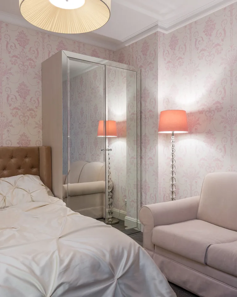 Pink floor lamp glowing beside a soft sofa in a stylish bedroom