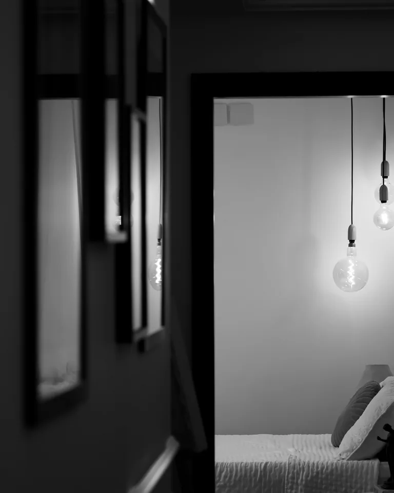 Black and white bedroom with Edison bulbs and framed art