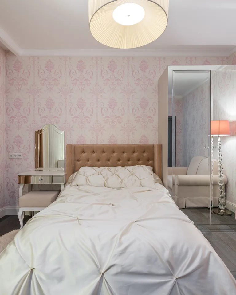 Bedroom with pink walls, glowing lamps, mirrored cupboard and curtains