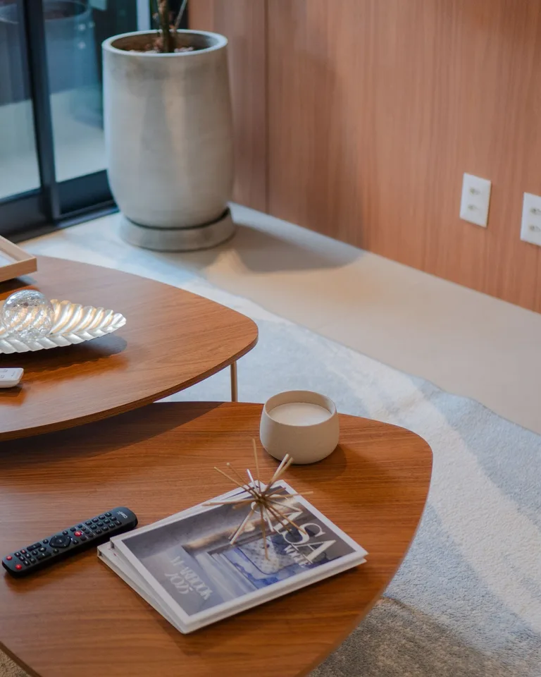 Wooden nesting coffee tables styled with books and a candle in a bright room