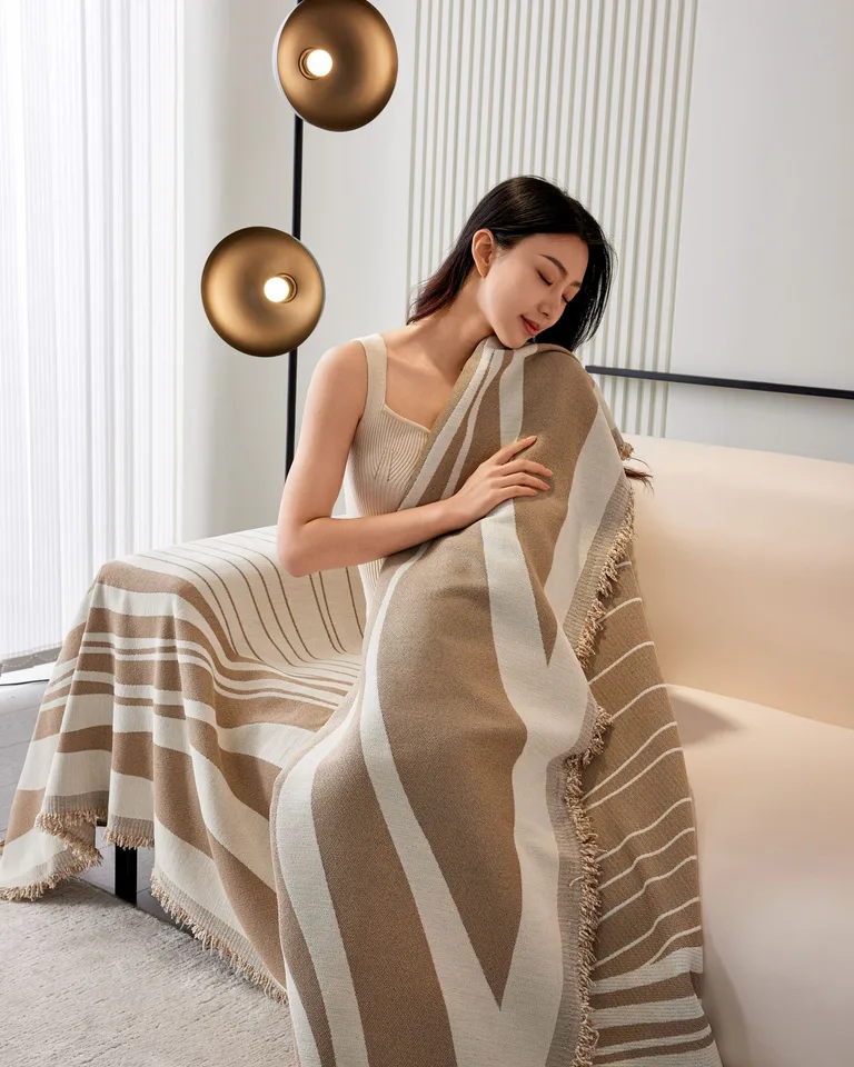 Striped woven throw blanket draped on a neutral sofa