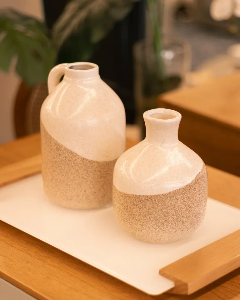 Neutral ceramic vases with a two-tone glaze on a wooden tray