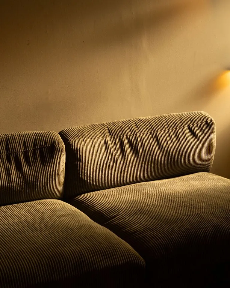 Corduroy sofa bathed in warm evening lamplight