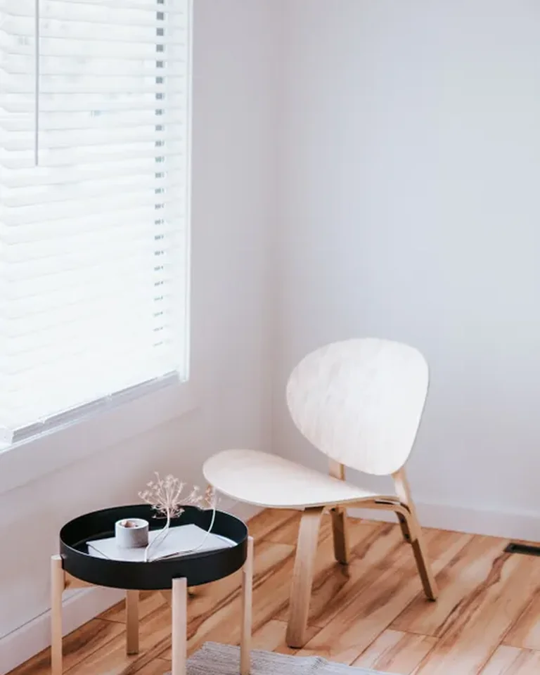 White accent chair next to a black side table in a bedroom corner